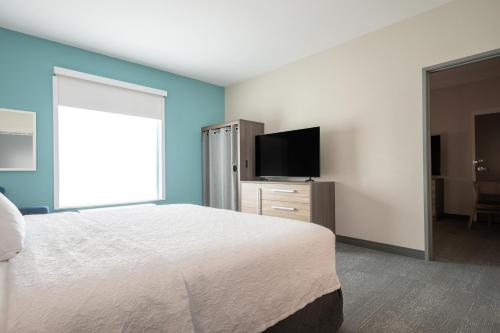 a bedroom with a bed and a flat screen tv at Home2 Suites by Hilton Fort Walton Beach Eglin AirForce Base in Fort Walton Beach
