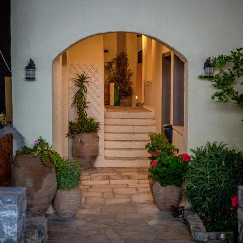 a front door of a house with potted plants at Porto Sisi Hotel Apartments in Sissi