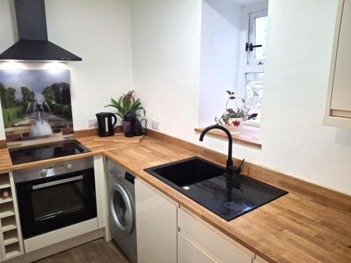a kitchen with a sink and a stove at Fenkle Street Alnwick Apartment in Alnwick