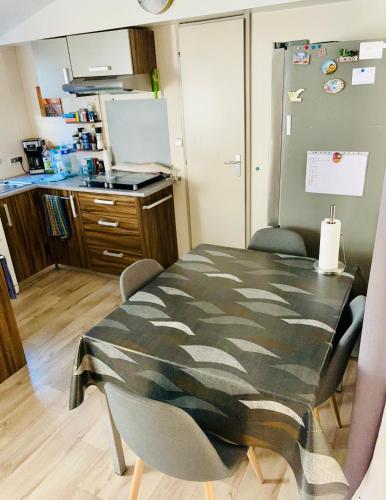 une cuisine avec une table et des chaises dans une pièce dans l'établissement Mobil home, à Puget-sur Argens