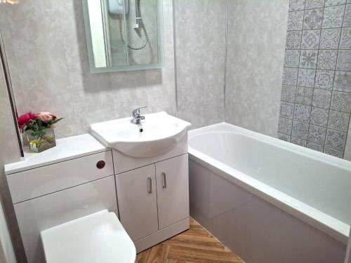 a bathroom with a sink and a tub and a toilet at Fenkle Street Alnwick Apartment in Alnwick