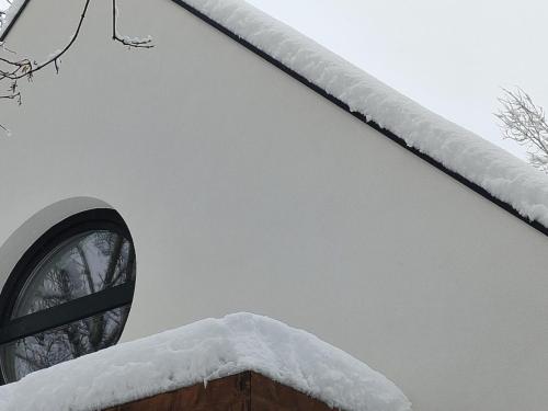 a building covered in snow with a window at MOHA Weekend in Bánk