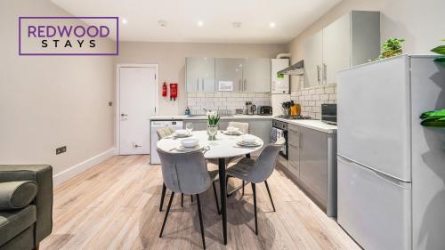 a kitchen and dining room with a table and chairs at Newly Refurbished Everest Lodge Serviced Apartments for Contractors & Families, FREE WiFi & Netflix by REDWOOD STAYS in Farnborough