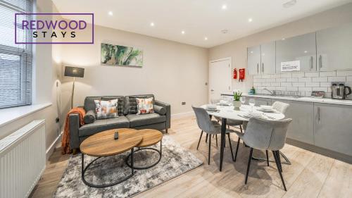 a kitchen and a living room with a table and a couch at Newly Refurbished Everest Lodge Serviced Apartments for Contractors & Families, FREE WiFi & Netflix by REDWOOD STAYS in Farnborough