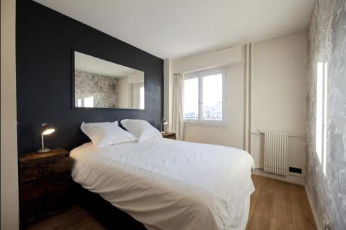 - une chambre avec un lit blanc et un mur noir dans l'établissement Amazing view, beautiful flat, swimming pools, secure parking, à Paris