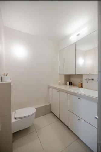 une salle de bain blanche avec des toilettes et un lavabo dans l'établissement Amazing view, beautiful flat, swimming pools, secure parking, à Paris