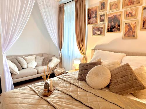 カロチャにあるCsatangoló Lovas Apartman Goldの大きなベッドとソファのある寝室