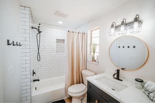 a bathroom with a sink and a toilet and a mirror at Game Room & Yard, Cozy, Family-Friendly Stay in Lutz