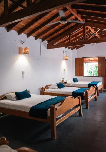 a group of three beds in a room at Encomendero Hotel -Centro Histórico- in Santa Fe de Antioquia