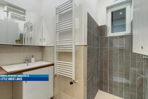 a bathroom with a sink and a shower at Little Americas Museum Apartments in Budapest