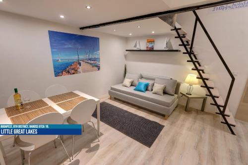 a living room with a couch and a stair case at Little Americas Museum Apartments in Budapest