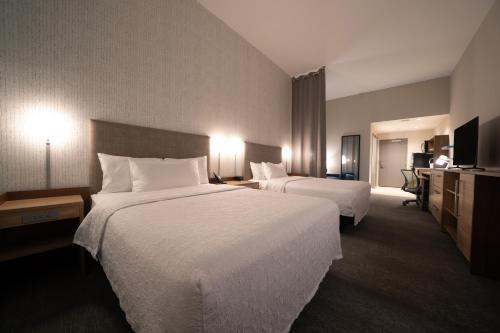 a hotel room with two beds and a television at Home2 Suites by Hilton Fort Walton Beach Eglin AirForce Base in Fort Walton Beach