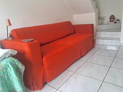 an orange couch sitting in a living room at Lar Suave Lar in Florianópolis