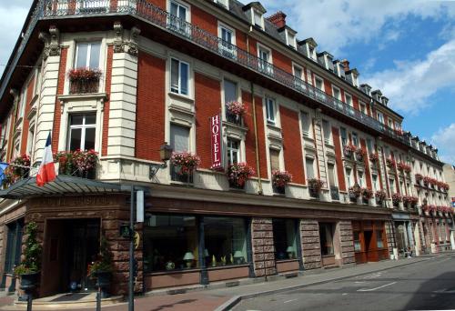 a large red brick building with flower boxes on it at Hotel Bristol in Mulhouse