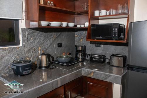 a kitchen with a counter top with a microwave at Valle Arenal in Fortuna