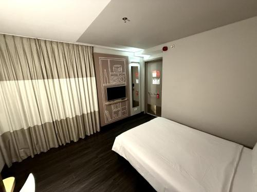 a bedroom with a white bed and a television at ibis Sao Paulo Ibirapuera in Sao Paulo