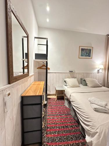 a room with two beds and a mirror and a rug at Charles V Marais Apartment in Paris