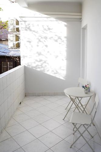 a white room with a table and a chair at Pécs Centrum Apartman in Pécs