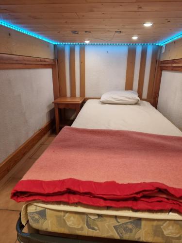 - un lit dans une petite chambre avec des lumières bleues dans l'établissement Signal du Prorel Briançon Serre Chevalier 