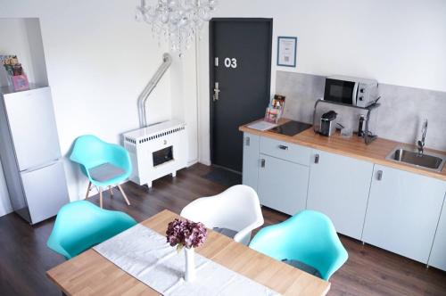 a kitchen with a table and some blue chairs at Pécs Centrum Apartman in Pécs