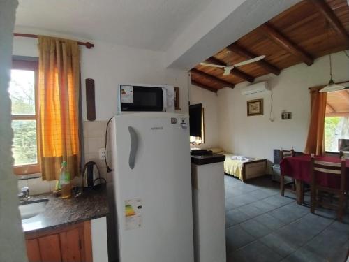 cocina con nevera y sala de estar. en Complejo de cabañas en Nono, en Nono