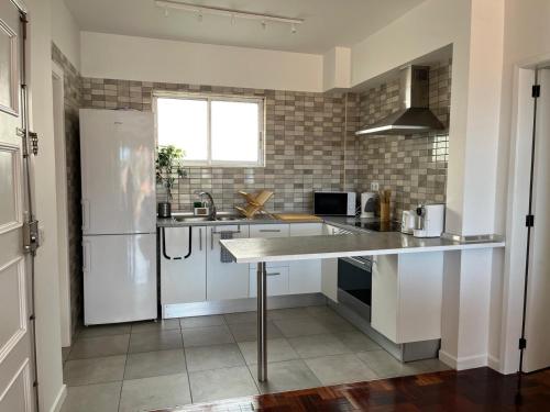 a kitchen with a white refrigerator and a sink at Cantinho dos M&M in Funchal