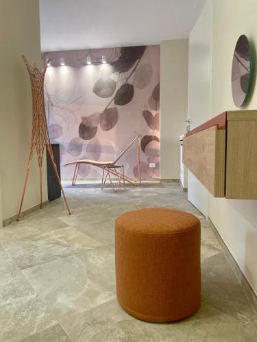an orange ottoman in a room with a wall at Pietralunga Resort in Fidenza