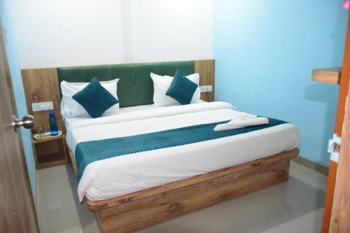 a bed with blue and white pillows in a room at JMB Hotel Rana Palace in Dewās