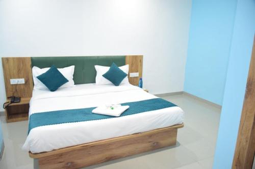 a bedroom with a bed with blue and white pillows at JMB Hotel Rana Palace in Dewās