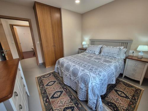 a bedroom with a bed and two rugs at Pensión Mariñeiro in Nigrán