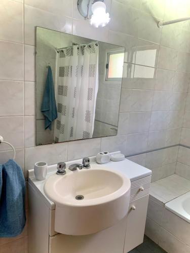 a white bathroom with a sink and a mirror at Lo de Viki in Lomas de Zamora