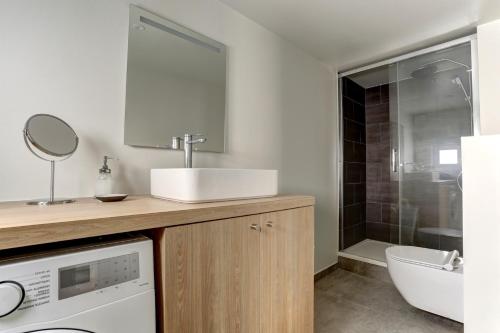 une salle de bain avec un lavabo et une machine à laver dans l'établissement Le Lazare, à Versailles