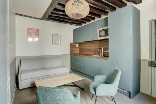 un salon avec un canapé, des chaises et une table dans l'établissement Le Lazare, à Versailles