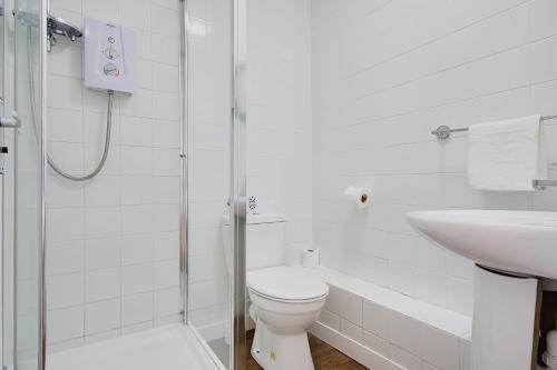 a white bathroom with a toilet and a sink at Azure Beach Hotel in Bournemouth