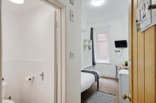 a small bathroom with a bed and a sink at Azure Beach Hotel in Bournemouth