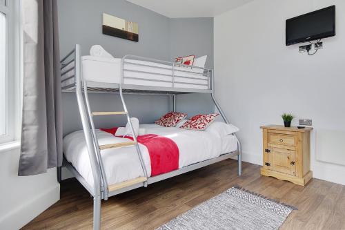 a bedroom with a bunk bed and a television at Azure Beach Hotel in Bournemouth