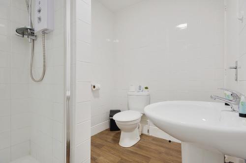 a white bathroom with a toilet and a sink at Azure Beach Hotel in Bournemouth