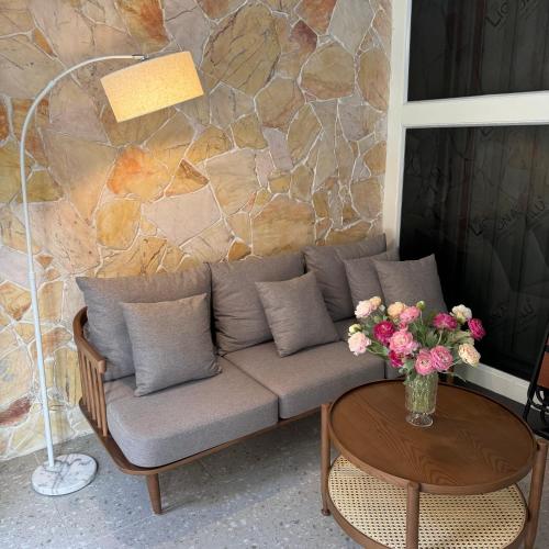 a couch and a table with a vase of flowers at Hayden Home Ocean Park 3 in Ðình Loan