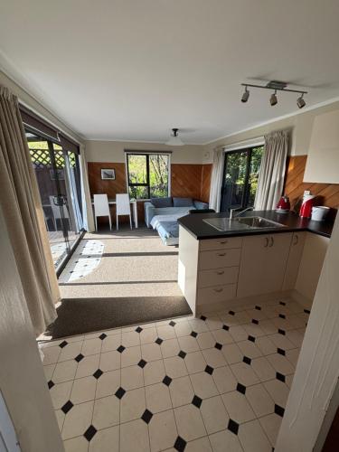 a kitchen with a sink and a living room at Ruakaka Retreat in Ruakaka