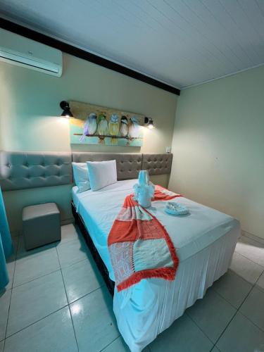 a bedroom with a large bed with a blanket on it at Hotel Porto Garden in Porto Seguro