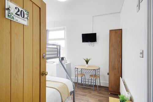 a bedroom with a bed and a table with a chair at Azure Beach Hotel in Bournemouth