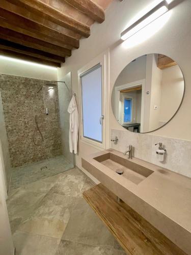 a bathroom with a sink and a mirror and a shower at Pietralunga Resort in Fidenza