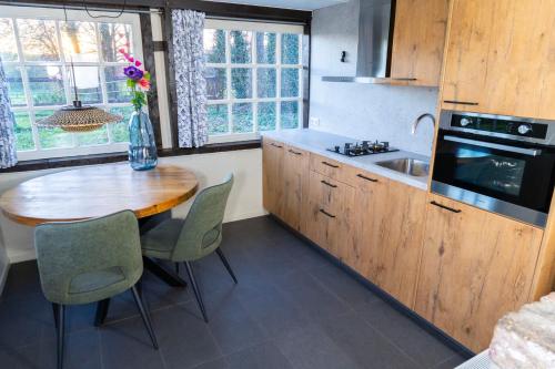 a kitchen with a wooden table and a sink at Vakantiewoningen 'Hoeve de Witte Olifant' in Noorbeek