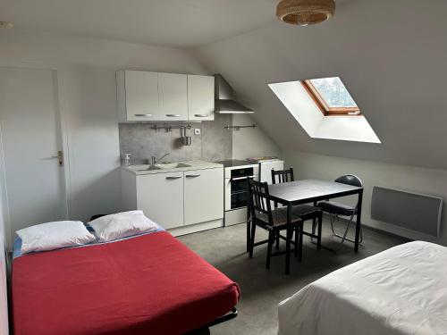 Cette chambre comprend un lit, une table et une cuisine. dans l'établissement Les Bords de la Lizaine, à Héricourt