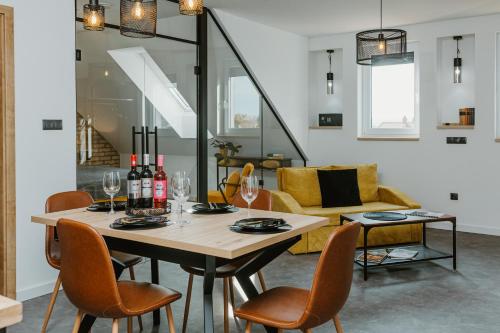una sala da pranzo con tavolo, bottiglie di vino e sedie di Ady54 a Tata