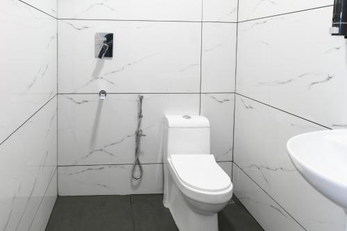 可瓦兰Hotel Samudra Tara的带马桶和水槽的白色浴室
