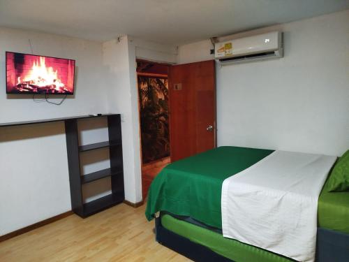 a bedroom with a bed and a tv on the wall at HOSTAL LA BOQUILLA in Cartagena de Indias