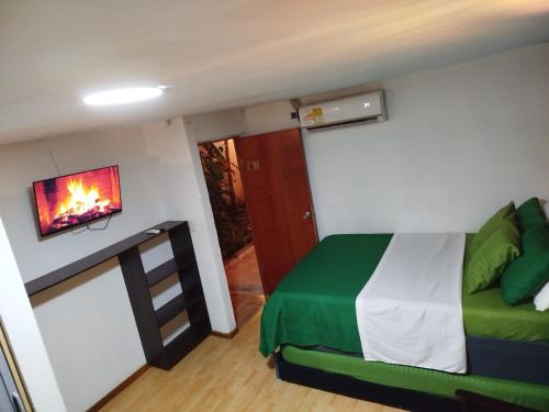 a bedroom with a bed and a tv on a wall at HOSTAL LA BOQUILLA in Cartagena de Indias