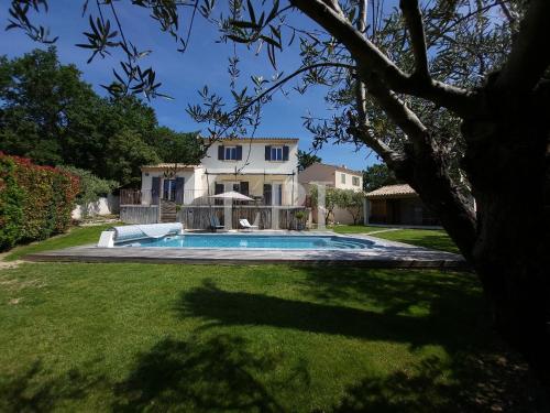 une maison avec une piscine dans une cour dans l'établissement L'escapade provençale, à Lioux