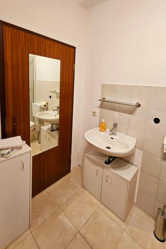 a bathroom with a sink and a mirror at Monteurzimmer Siebenlehn in Siebenlehn